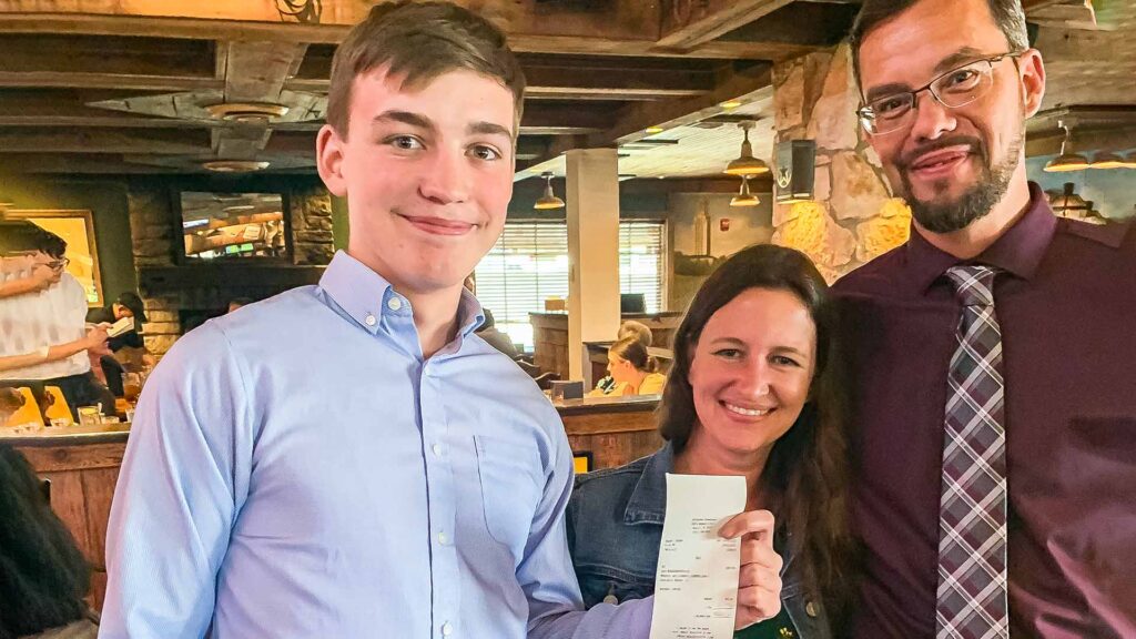 John holding a receipt of a group lunch that he paid for